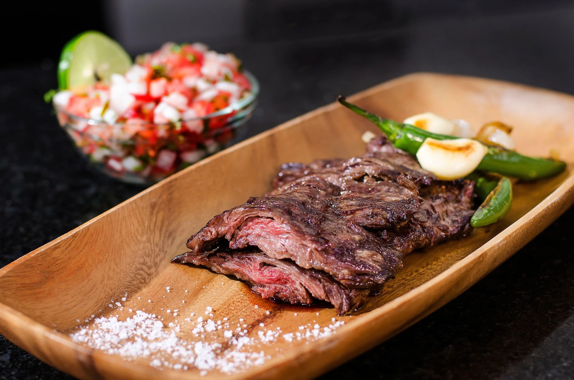 Authentic grilled carne asada sliced and served with tortillas, lime, cilantro, and avocado.